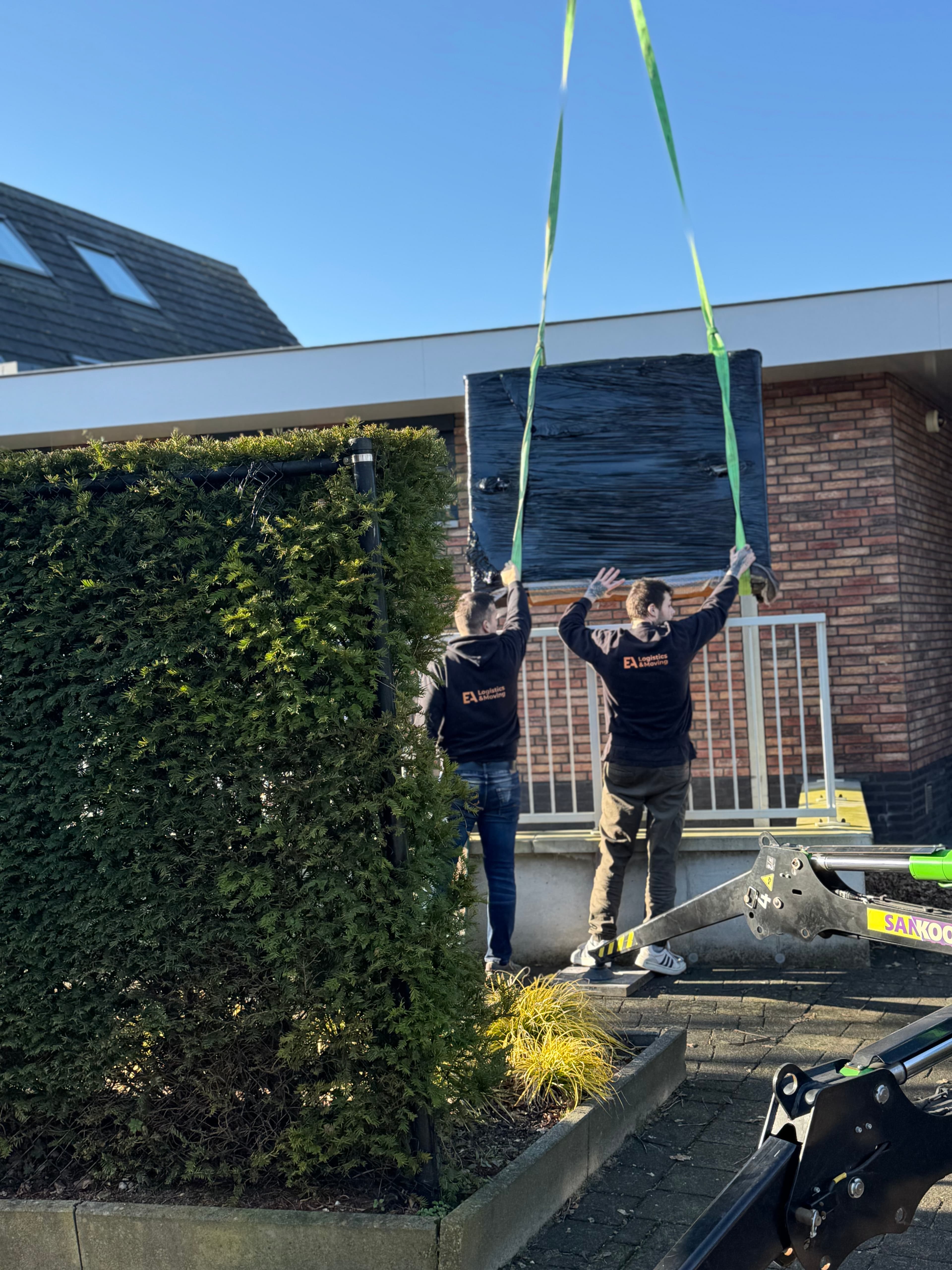 Medewerkers van EA Logistics & Moving met verhuislift